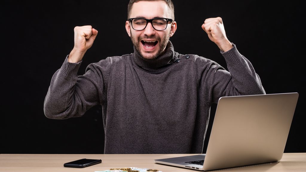 trabajador-de-oficina-triunfante-logro-hacer-un-buen-negocio-en-linea-hombre-ganador-en-mesa-con-laptop-telefono-y-dinero-con-bitcoin trabajador-de-oficina-triunfante-logro-hacer-un-buen-negocio-en-linea-hombre-ganador-en-mesa-con-laptop-telefono-y-dinero-con-bitcoin