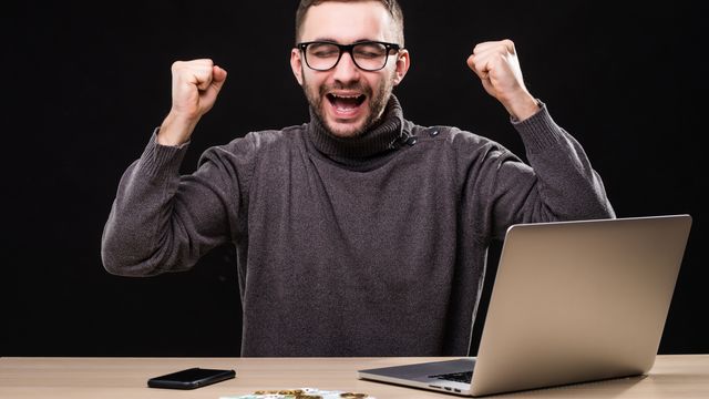 trabajador-de-oficina-triunfante-logro-hacer-un-buen-negocio-en-linea-hombre-ganador-en-mesa-con-laptop-telefono-y-dinero-con-bitcoin trabajador-de-oficina-triunfante-logro-hacer-un-buen-negocio-en-linea-hombre-ganador-en-mesa-con-laptop-telefono-y-dinero-con-bitcoin