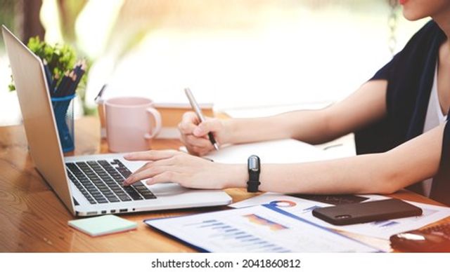 asian-woman-working-through-laptop-260nw-2041860812