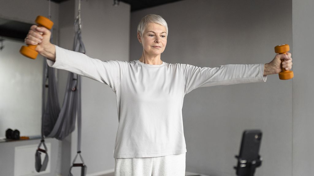 senior-woman-filming-herself-doing-fitness-exercises-gym